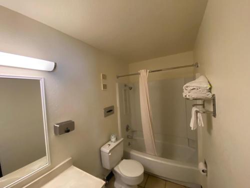 a bathroom with a shower and a toilet and a tub at Simple Rewards Inn in Ruidoso