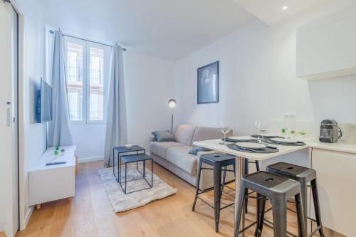 - un salon avec un canapé et une table avec des tabourets dans l'établissement Stylish 1-Bedroom Apartment in the City Center, à Cannes