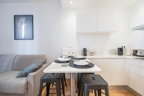 a white kitchen with a table with wine glasses on it at SERRENDY NEW 1-bedroom apartment in the city center in Cannes