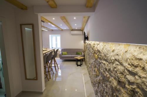 una sala de estar con una pared de piedra y un bar en Apartment Ispod ure, en Sinj