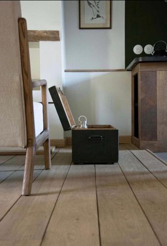 een keuken met een stoel en een doos op de vloer bij Le Roitelet - Suite d'hôtes privative in Montcavrel