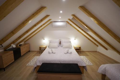 una camera mansardata con letto con lenzuola e cuscini bianchi di Apartment Ispod ure a Sinj (Signo)