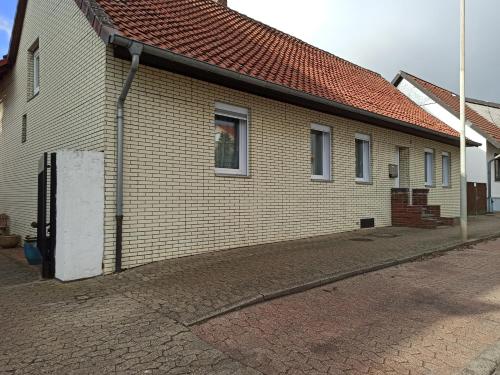 un edificio de ladrillo con techo rojo en una calle en Gasthaus Katrin en Königslutter am Elm