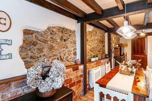 cocina con pared de piedra y mesa en Casa Conce Zona de playa y montaña en Llanes