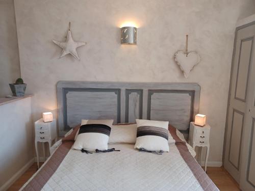 a bedroom with a bed with two pillows on it at Le studio côté chapelle in Coursegoules