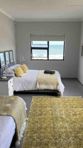 a bedroom with two beds and a window at Bakgat Stay - Seafront 7-sleeper holiday home in Struisbaai