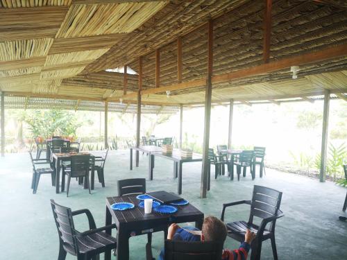 a person sitting in a chair at a restaurant at Glamping Amazonas in Leticia
