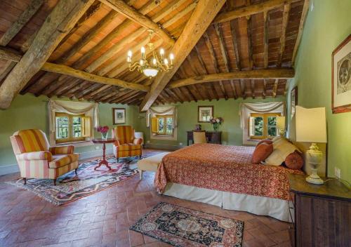 una camera con un grande letto in una stanza con soffitti in legno di Casa del Fattore by MC Luxury Rentals a Capannori