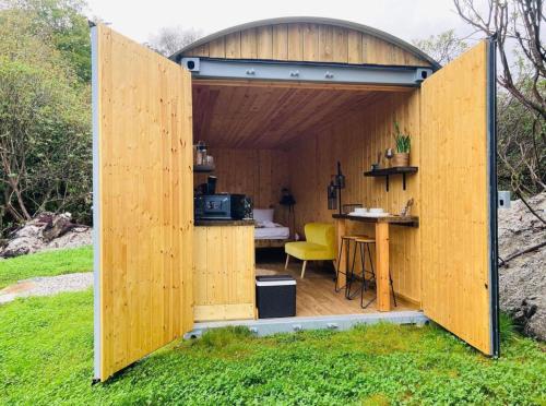 a wooden pavilion with a table in the grass at Trethowels Hidden Huts in St Austell