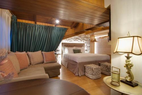 a bedroom with a bed and a couch in a room at ARCHONTARIKI Historic Boutique Hotel in Ioannina