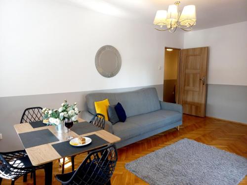 ein Wohnzimmer mit einem Sofa und einem Tisch in der Unterkunft Corner Apartament Piłsudskiego - 5 min od Dworca Głównego - Main Railway Station in Breslau