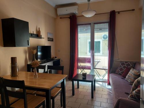 un soggiorno con tavolo e divano di Menecrates Corfu Town Apartment a Città di Corfù