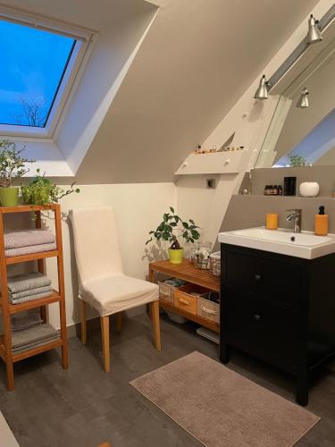 - une cuisine mansardée avec un évier et une chaise dans l'établissement Chez Béa, à Granville