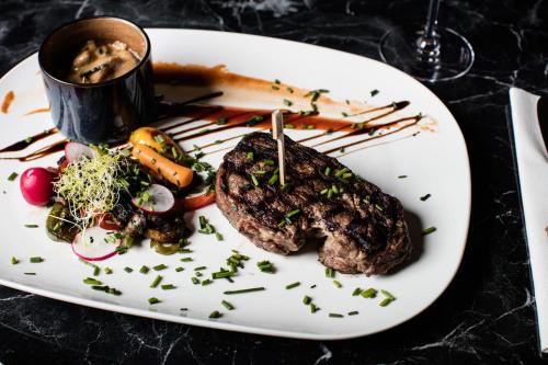 a plate of food with a steak and vegetables at Hotel Du Commerce in Oostburg