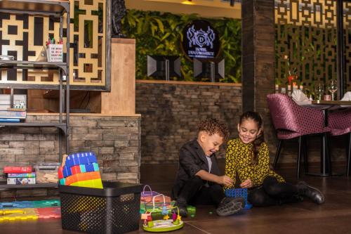 a boy and a girl sitting on the floor in a room at Hotel Du Commerce in Oostburg
