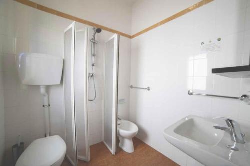 een witte badkamer met een toilet en een wastafel bij Hotel Splendid in Gabicce Mare