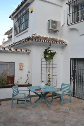 patio ze stołem i 2 krzesłami oraz budynek w obiekcie Suite Estudio Montaña w mieście Torremolinos