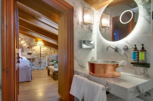 a bathroom with a copper sink and a mirror at ARCHONTARIKI Historic Boutique Hotel in Ioannina