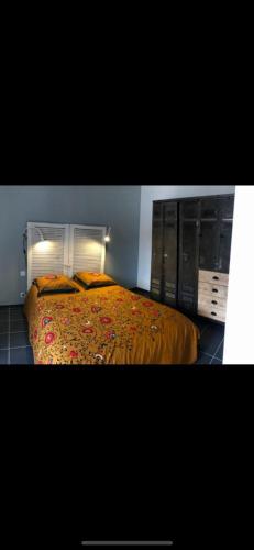 - une chambre avec un lit doté d'un couvre-lit orange dans l'établissement Le cosy roannais, à Roanne