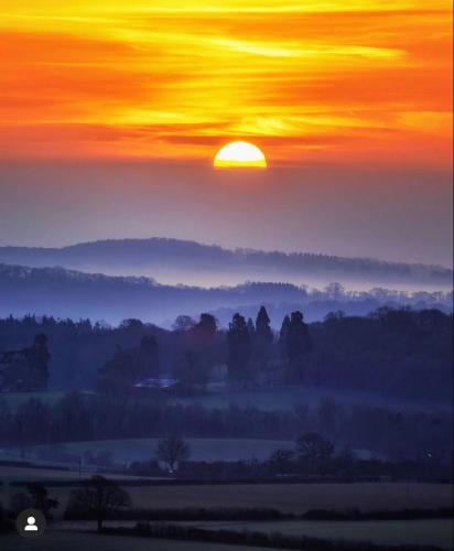 a sunset with the sun rising over a field at Shepherds Gate at The Royal Oak Much Marcle in Preston