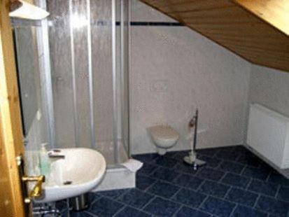 a bathroom with a sink and a shower and a toilet at Hotel Brückenmühle in Meiningen