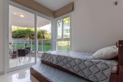 1 dormitorio con 1 cama y balcón con mesa en In Mare #26 - Apartamento na Praia por Carpediem, en Parnamirim