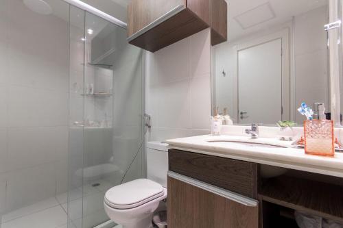 uma casa de banho com um WC, um lavatório e um chuveiro em In Mare #26 - Apartamento na Praia por Carpediem em Parnamirim