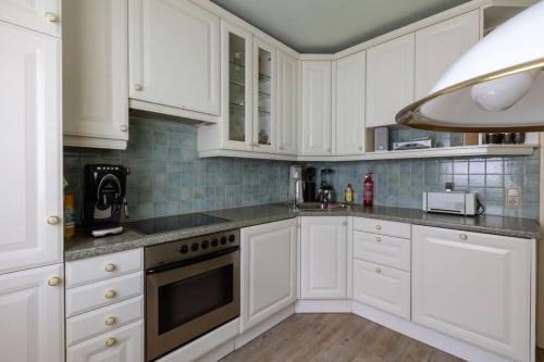 a kitchen with white cabinets and a stove top oven at Wohnung in Zentrumsnähe beim Hauptbahnhof (100 m2) in Vienna