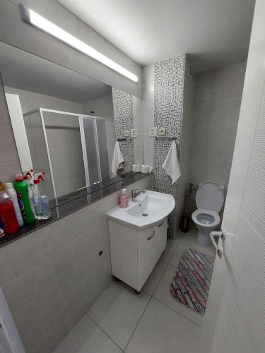 a white bathroom with a sink and a toilet at Luxury Apartment Eurotel in Struga