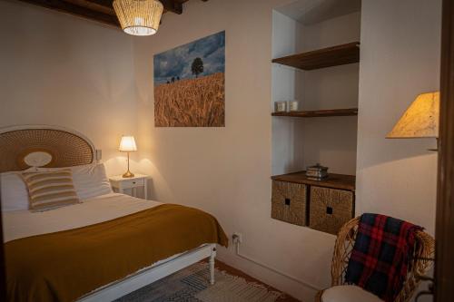 a bedroom with a bed and a picture on the wall at A Casa da Ti Vina in Gavião