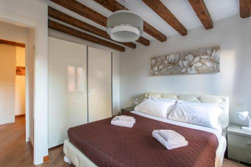 sypialnia z dużym łóżkiem z dwoma ręcznikami w obiekcie Ca Francesca w Wenecji