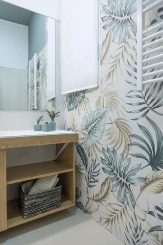 a bathroom with a wall mural of leaves at El Rincón Encantado in Cuenca