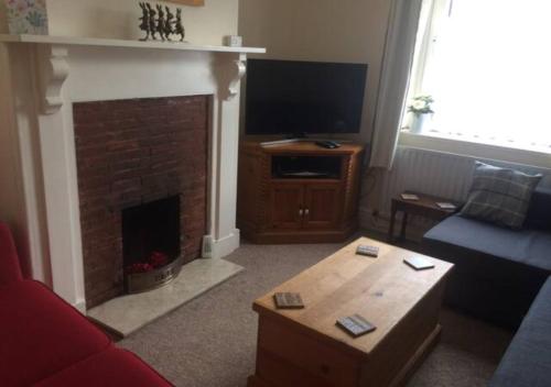 a living room with a fireplace and a tv at 4 Bedroom House For Corporate Stays in Kettering in Isham