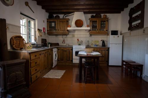 a kitchen with wooden cabinets and a table in it at A Casa da Ti Vina in Gavião