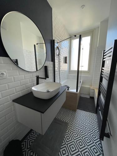 ein Badezimmer mit Waschbecken und Spiegel in der Unterkunft L'Appartement Bleu - Logement cosy - Cœur de ville in Douai