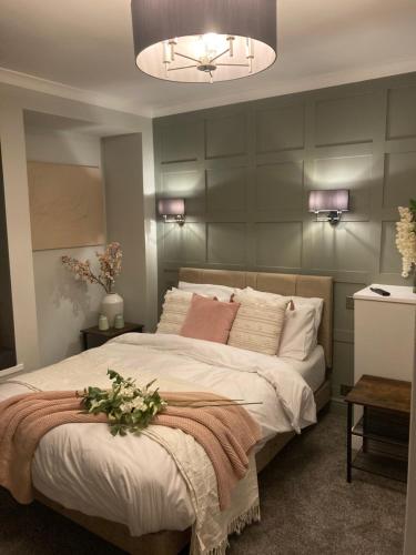a bedroom with a large bed with a flower arrangement on it at Abbey Court Guest House in Carlisle