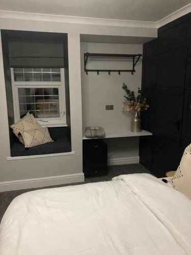 a bedroom with a white bed and a window at Abbey Court Guest House in Carlisle