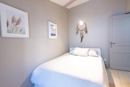 biała sypialnia z łóżkiem i lustrem w obiekcie Domus Arena, parking, wifi, arènes w mieście Nîmes