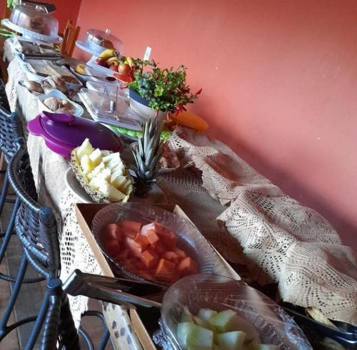 a long table with many plates of food on it at pousada jalapão arco iris in Mateiros