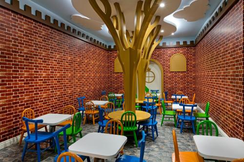 a room with tables and chairs and a tree on the wall at Limak Cyprus Deluxe Hotel in Iskele