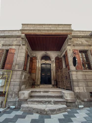 an old building with a black door and stairs at Kerem ile Aslı Butik Hotel in Melikgazi