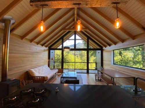 a living room with a large window in a house at Luxury mountain loft in Pucón