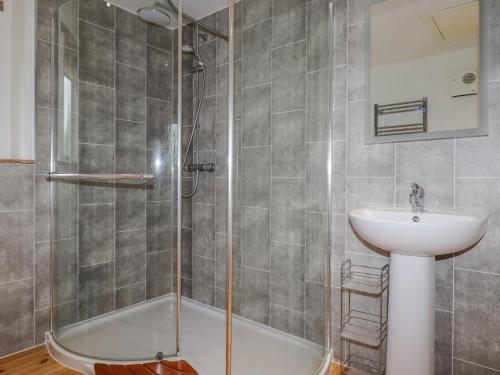 a bathroom with a shower and a sink at Vine Cottage in Saint Ewe