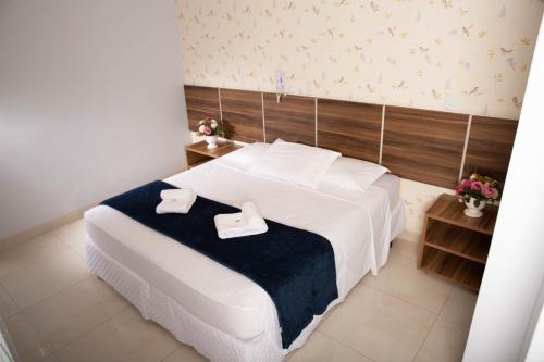 1 dormitorio con 1 cama blanca grande y 2 toallas en Hotel Araguaia, en Palmas