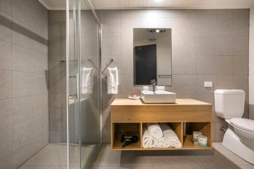 a bathroom with a sink, toilet and shower stall at Nightcap at Macquarie Inn in Dubbo