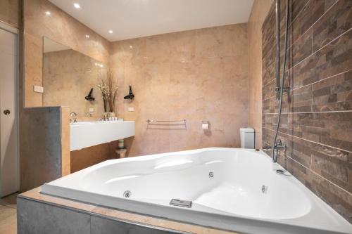 a bathroom with a large tub and a sink at Nightcap at Macquarie Inn in Dubbo