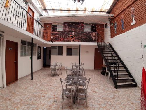 een kamer met een tafel en stoelen en een trap bij Hotel COMIC CITY in Bogota