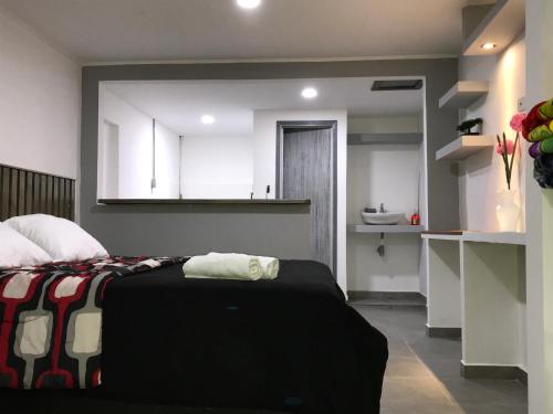 a bedroom with a bed and a bathroom with a sink at Makana apartastudio in Salento