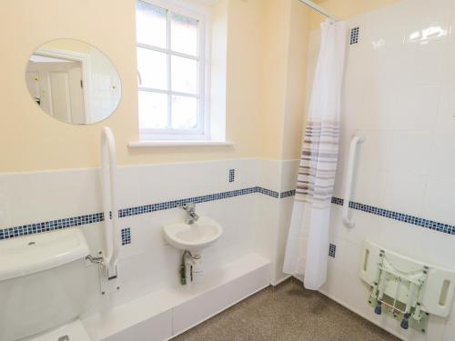 a bathroom with a sink and a tub and a mirror at No 3 Low Hall Cottages in Scalby