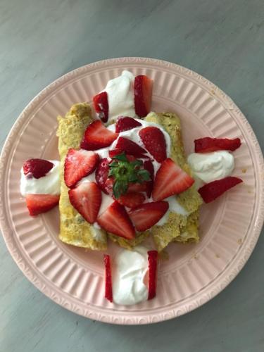 a white plate with strawberries and whipped cream at Hope Bed and Breakfast in Canton